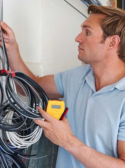 Man doing DIY electrical rewiring of renovated home