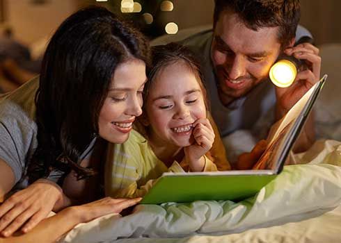 Family reading together with a flashlight during a power outage